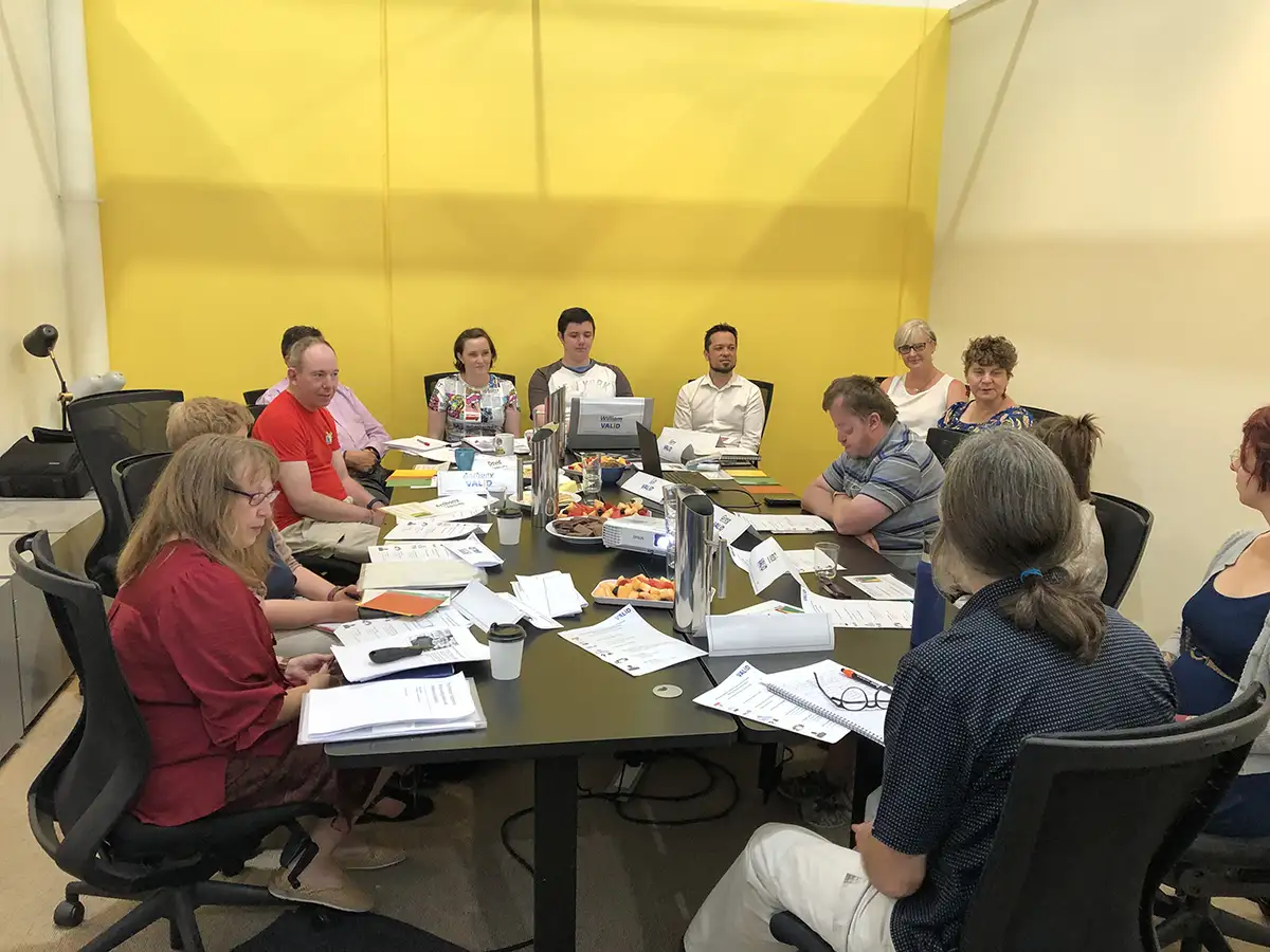 Group of Valid members seated around a large table having an important meeting